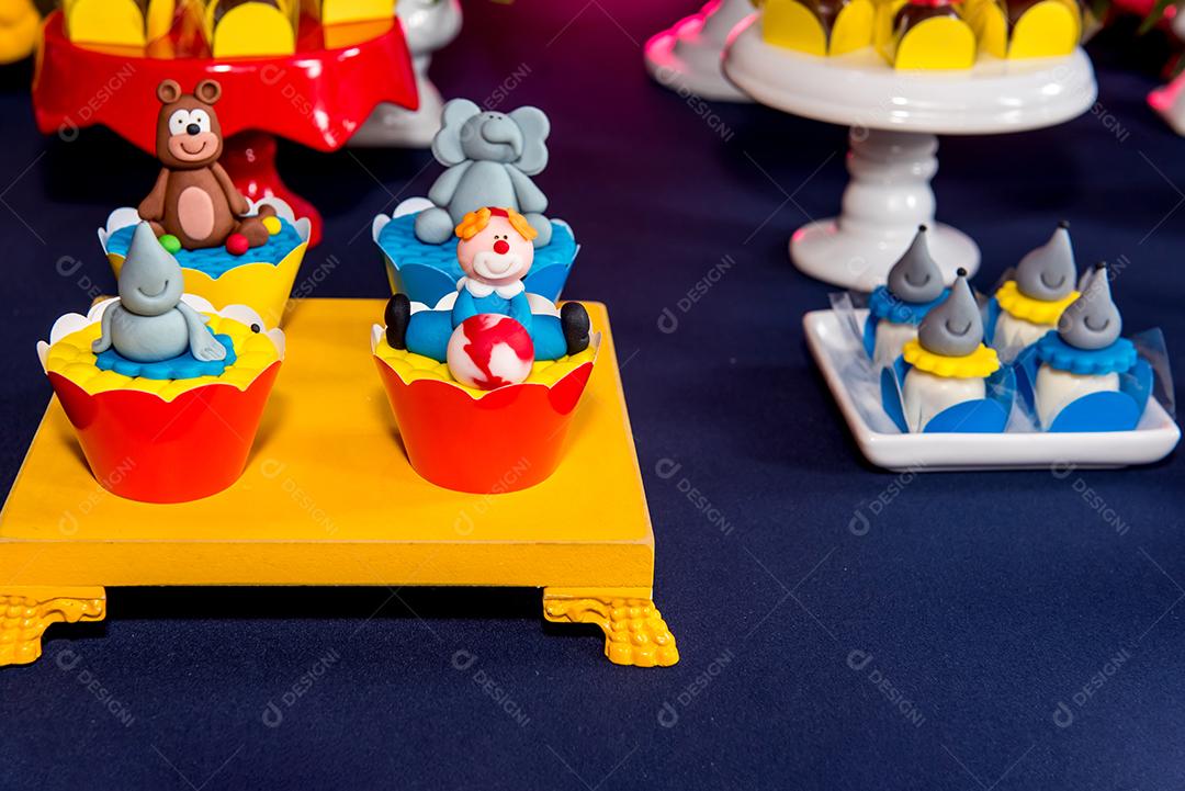 Mesa com doces e muffins decorados com glacê real