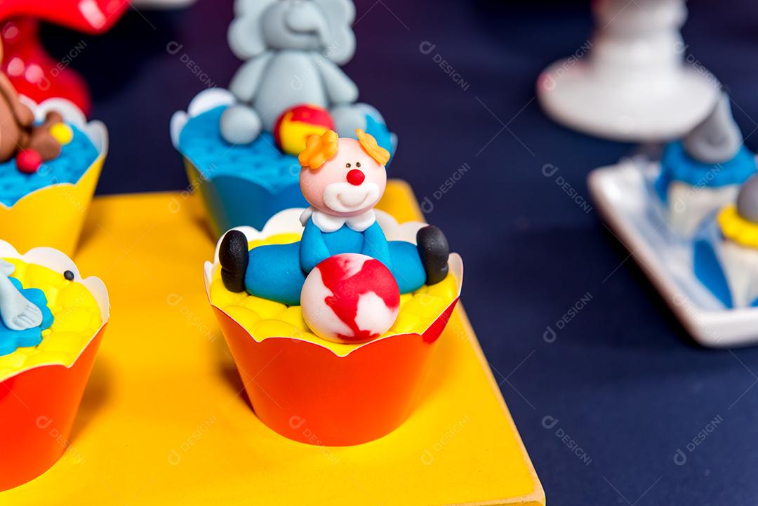 Mesa com doces e muffins decorados com glacê real