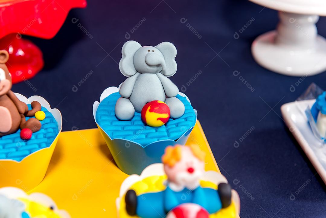 Mesa com doces e muffins decorados com glacê real