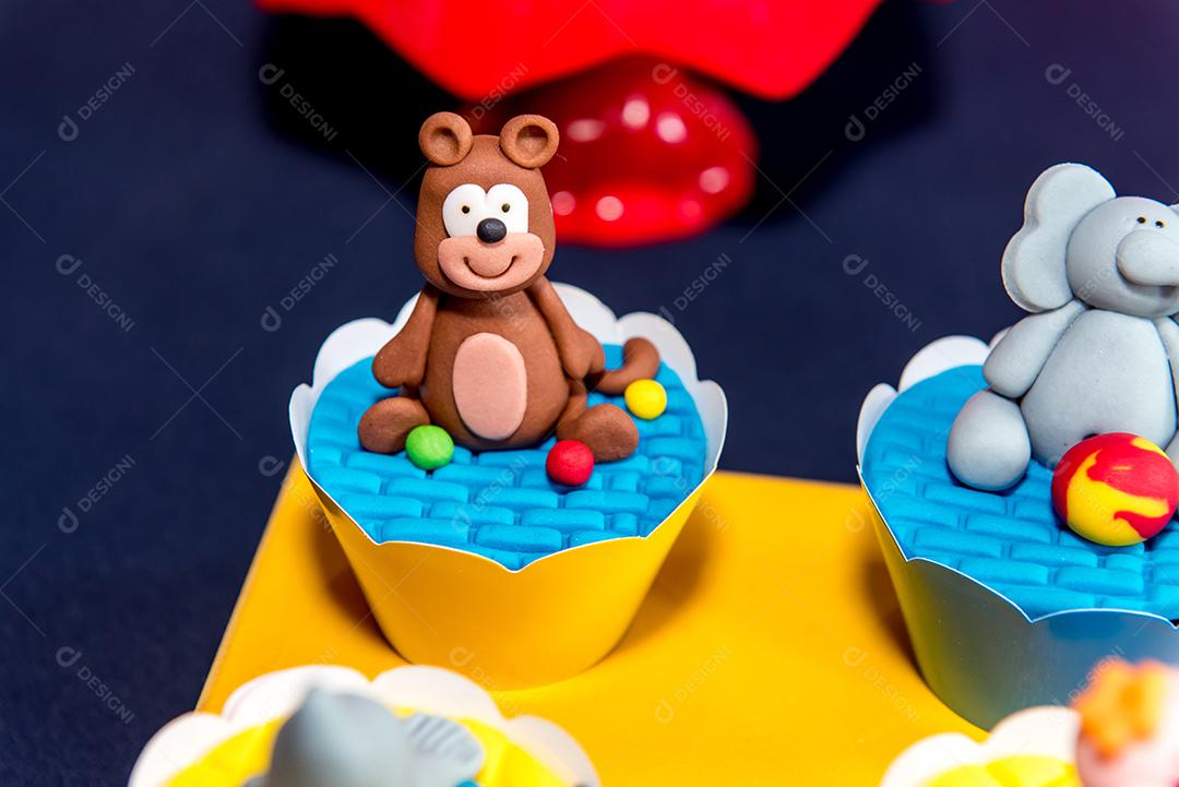 Mesa com doces e muffins decorados com glacê real