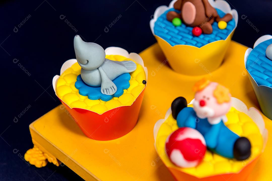 Mesa com doces e muffins decorados com glacê real