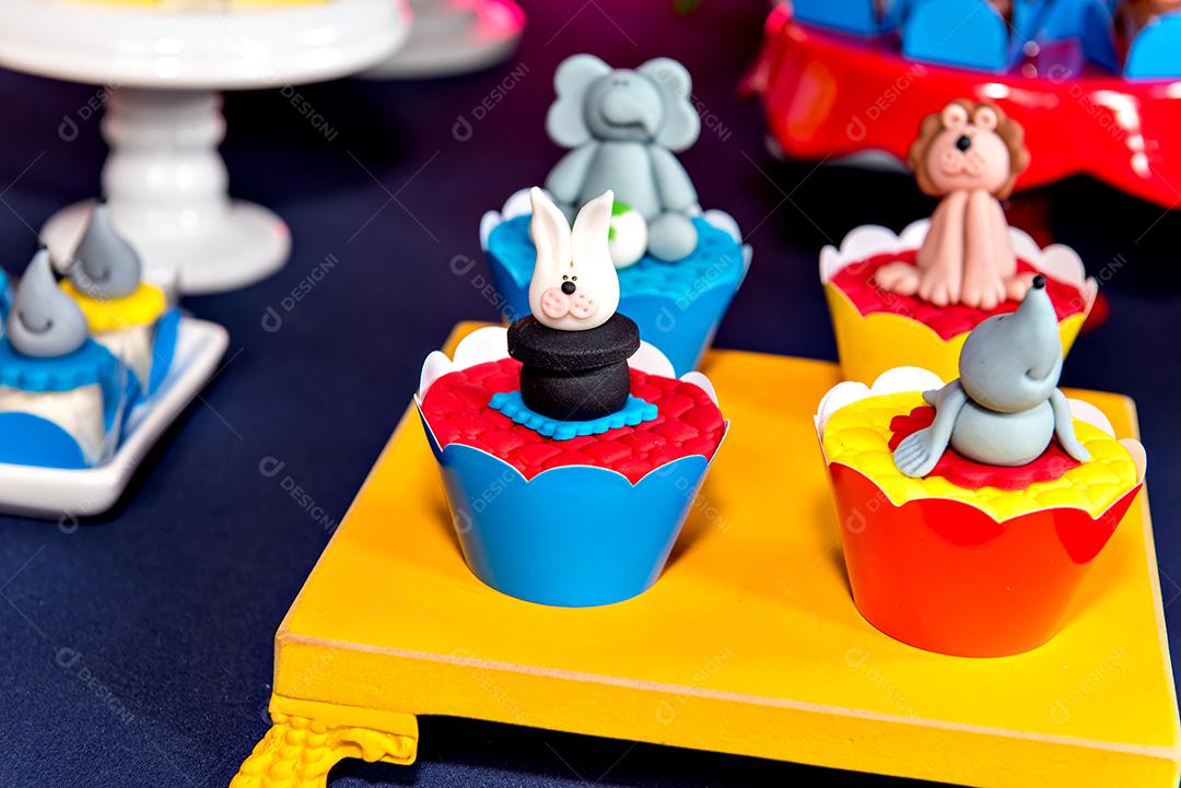 Mesa com doces e muffins decorados com glacê real