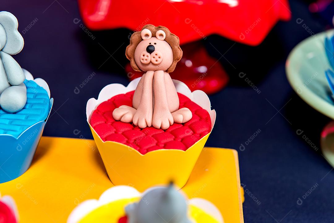 Mesa com doces e muffins decorados com glacê real