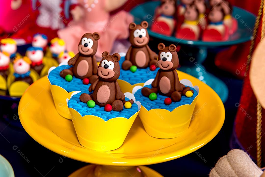 Mesa com doces e muffins decorados com glacê real