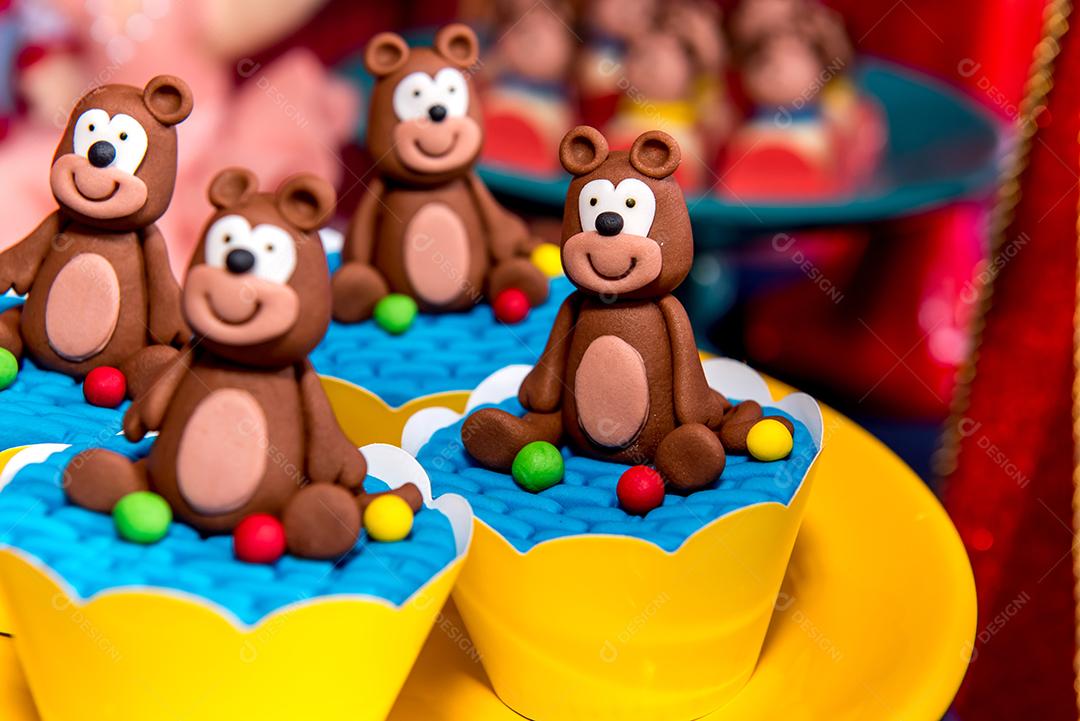 Mesa com doces e muffins decorados com glacê real