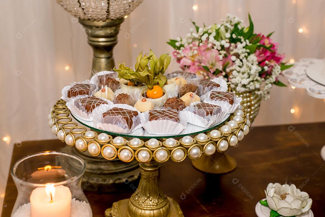 Mesa com doces e muffins decorados com glacê real