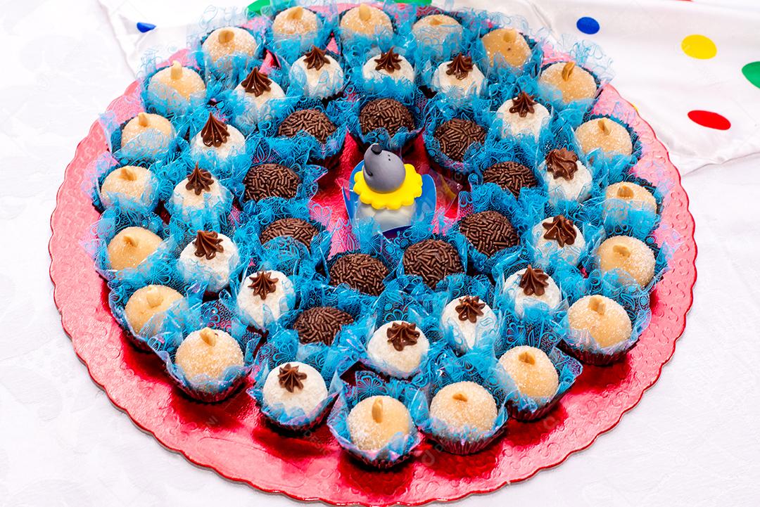 Mesa com doces e muffins decorados com glacê real