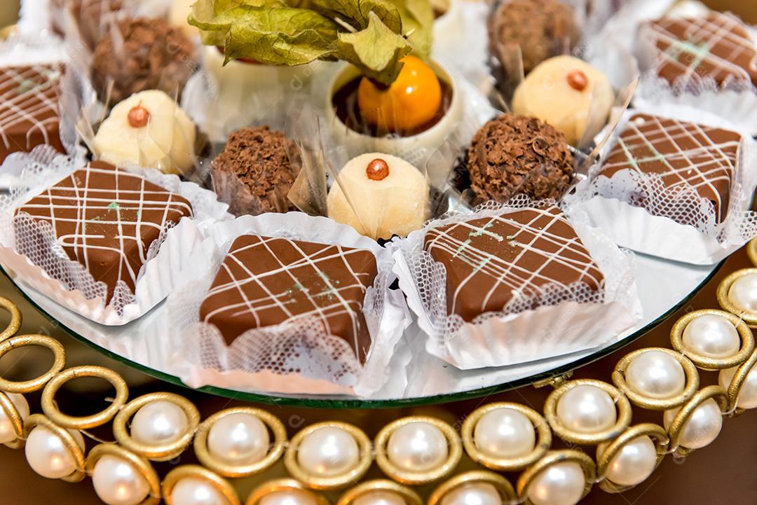 Mesa com doces tradicionais de festa brasileira. Chocolate, brigada