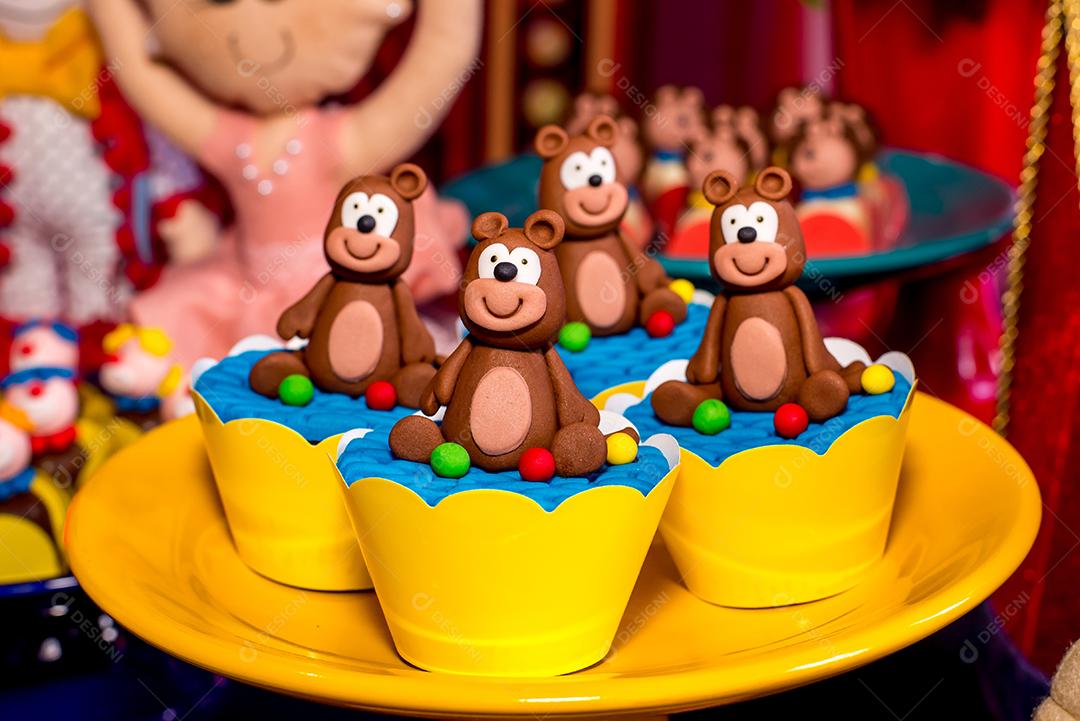 Mesa com doces e muffins decorados com glacê real