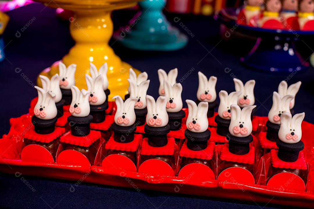 Mesa com doces e muffins decorados com glacê real