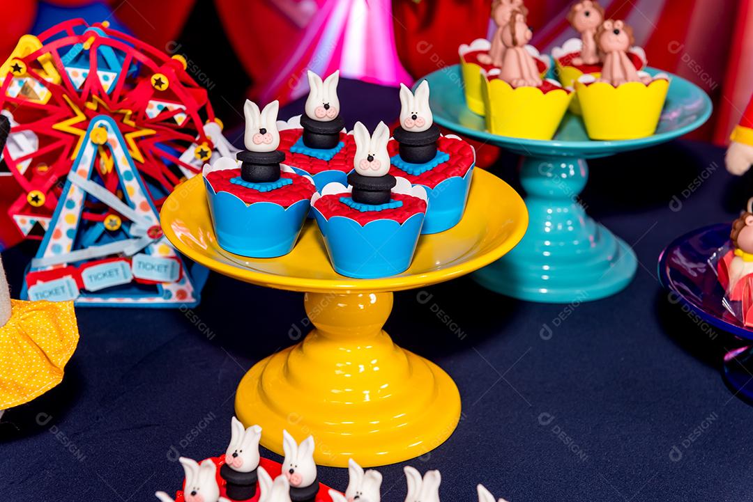 Mesa com doces e muffins decorados com glacê real