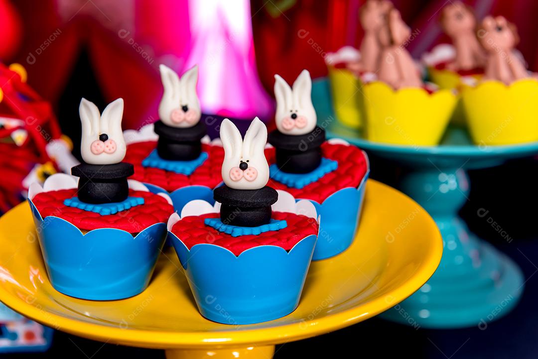 Mesa com doces e muffins decorados com glacê real