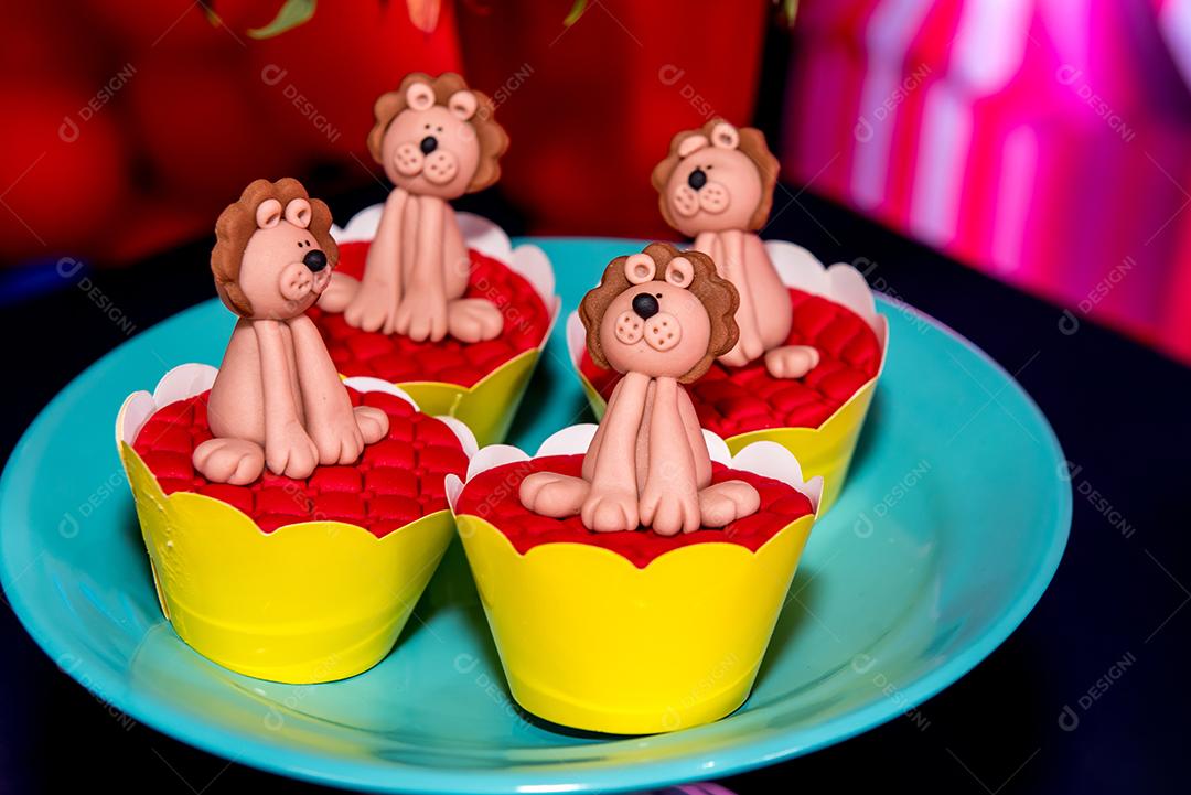 Mesa com doces e muffins decorados com glacê real