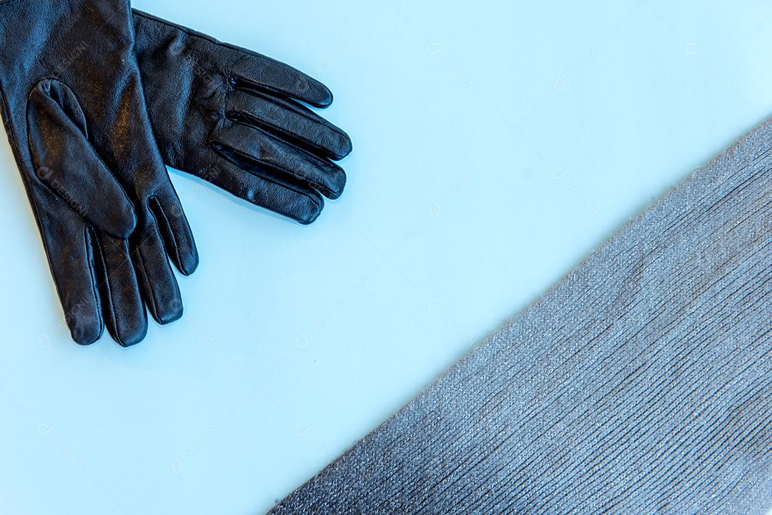 Luva e cachecol sobre fundo azul. Vista do topo.