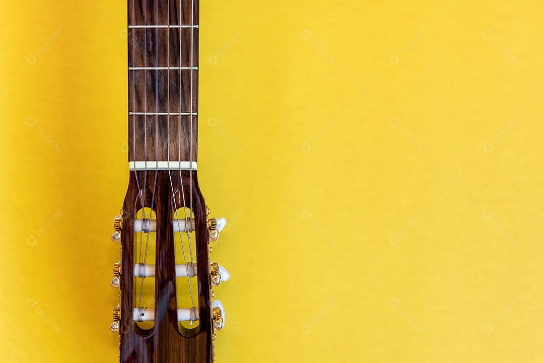 Pescoço de guitarra em fundo amarelo. Vista do topo.