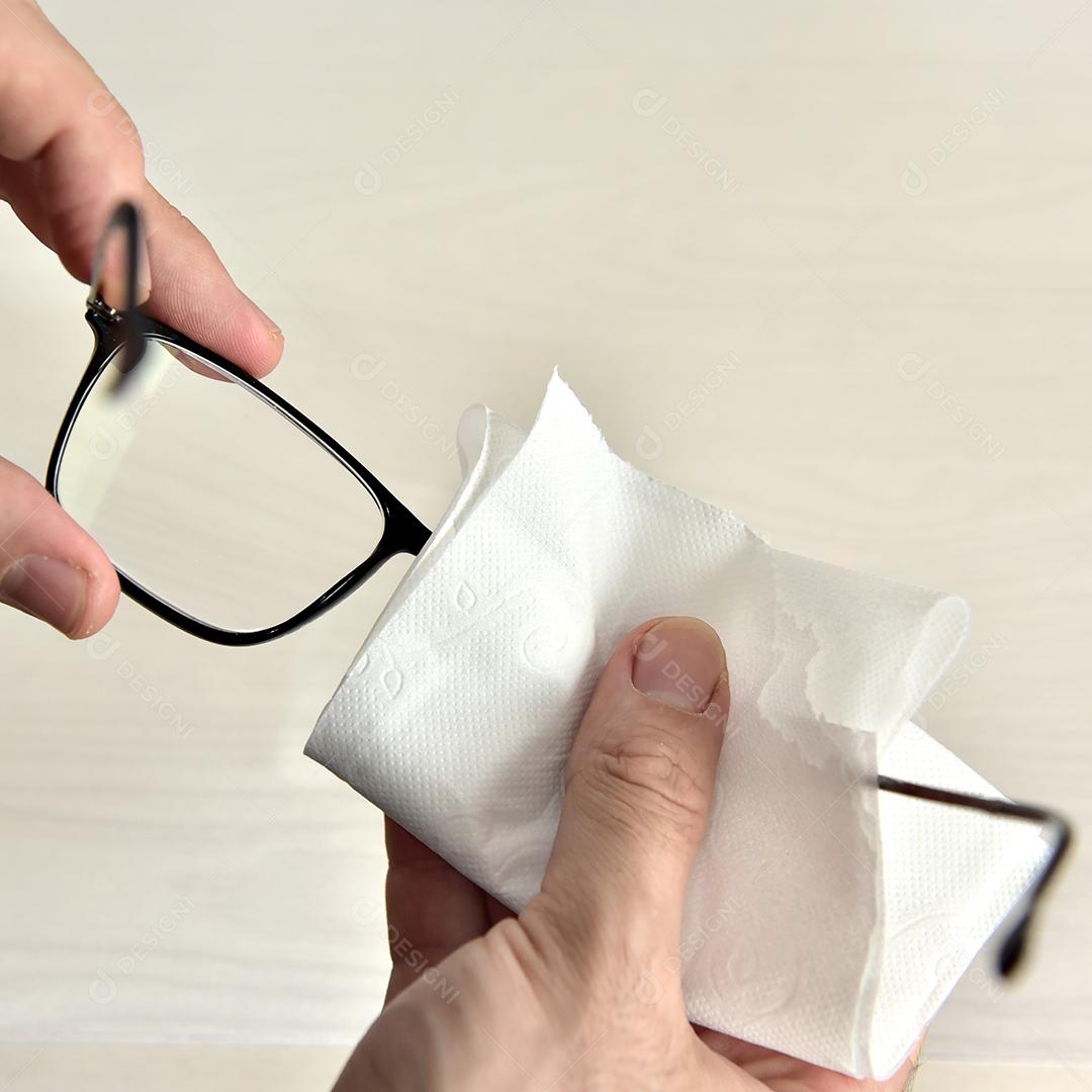 Mãos de pessoas limpando óculos lenço