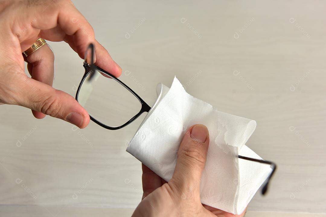 Mãos de pessoas limpando óculos lenço