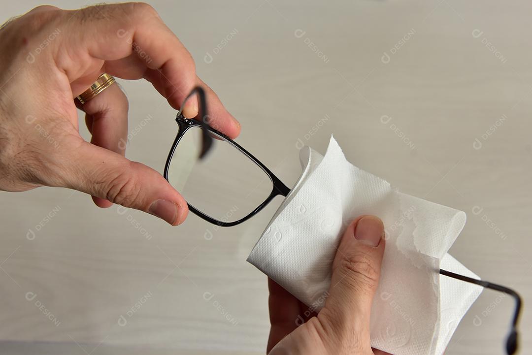 Mãos de pessoas limpando óculos lenço