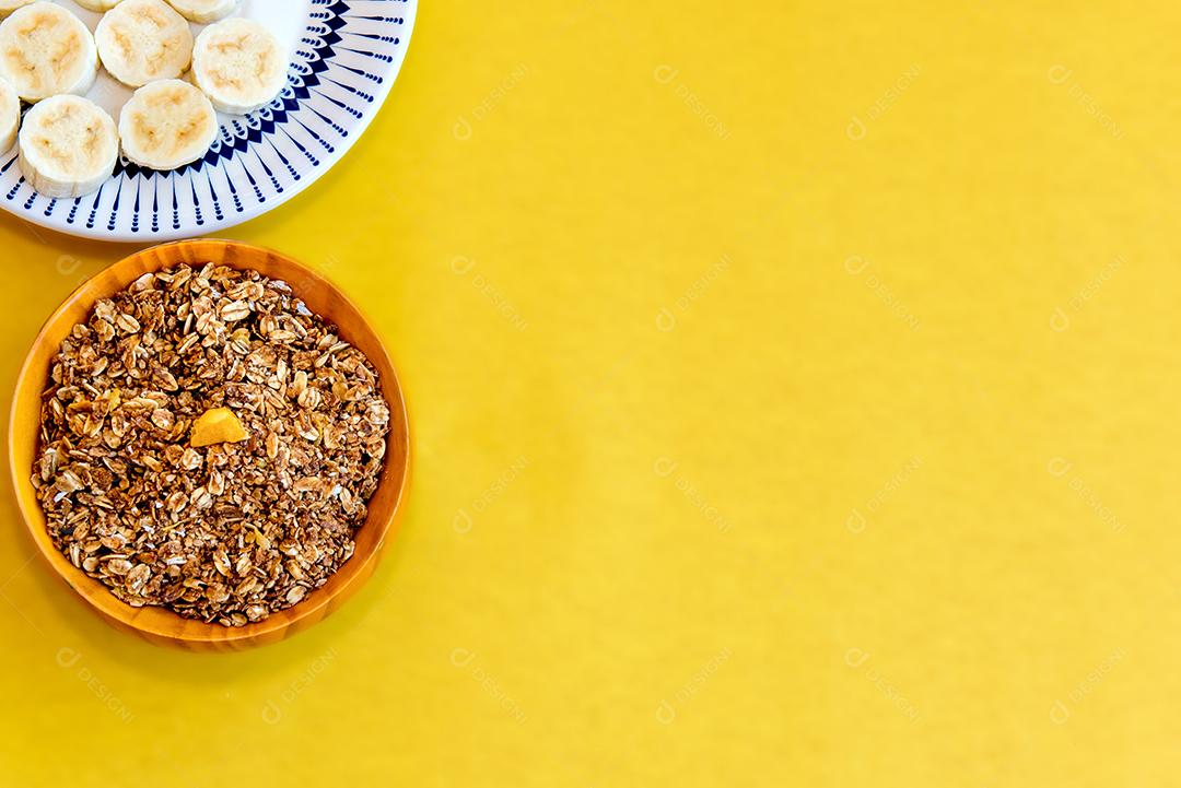 Prato com bananas fatiadas e granola. Vista do topo.