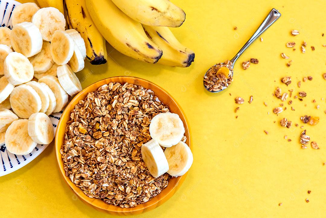 Prato com bananas fatiadas e granola. Vista do topo.