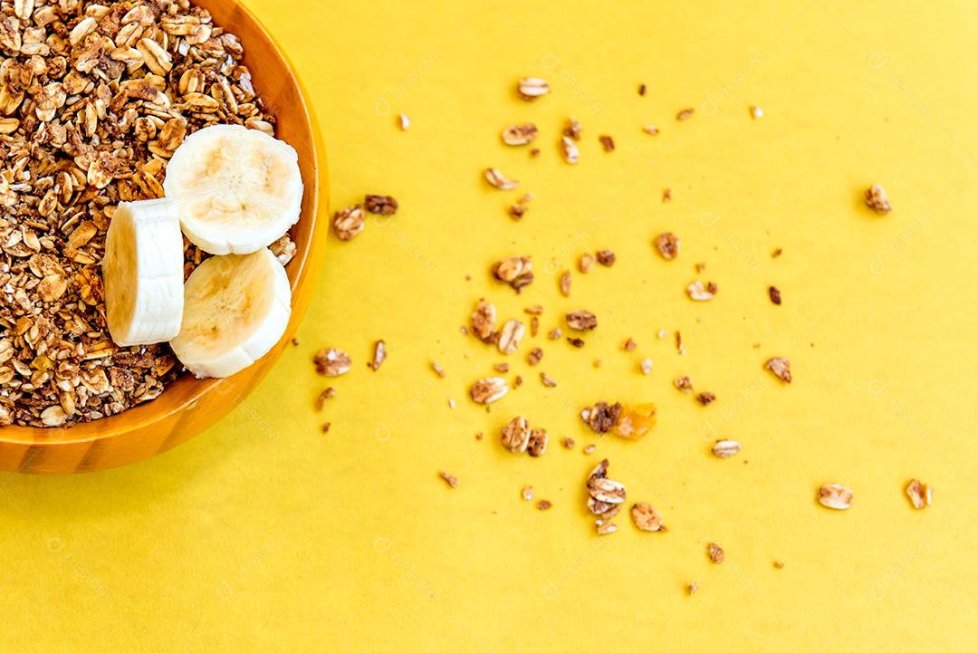 Prato com bananas fatiadas e granola. Vista do topo.