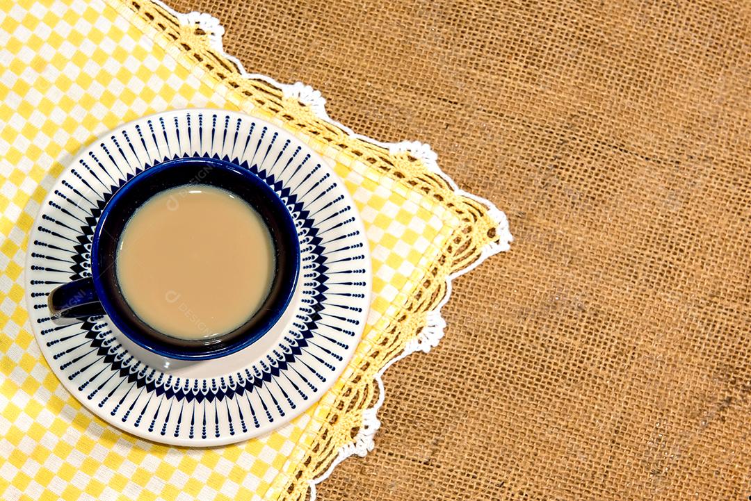 Xícara com café com leite na mesa colonial. Vista do topo.