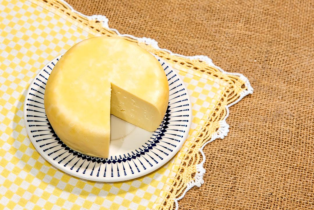 Queijo na mesa colonial. Textura rústica amarela.