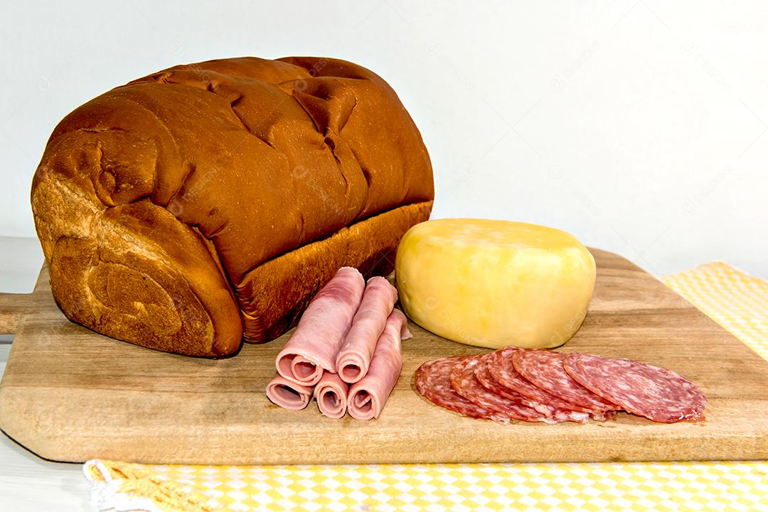 Café da manhã colonial servido com pão, queijo, presunto e salame.