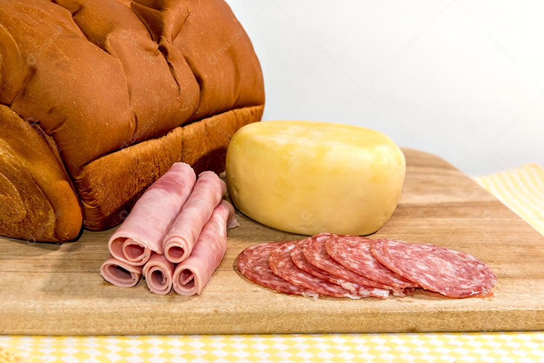 Café da manhã colonial servido com pão, queijo, presunto e salame.