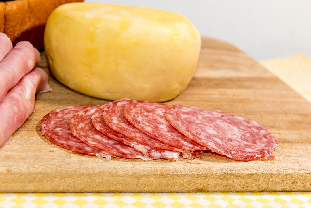 Café da manhã colonial servido com pão, queijo, presunto e salame.