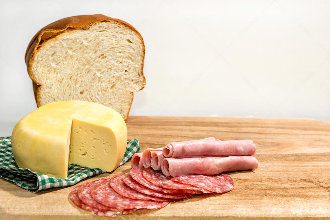 Café da manhã colonial servido com pão, queijo, presunto e salame.