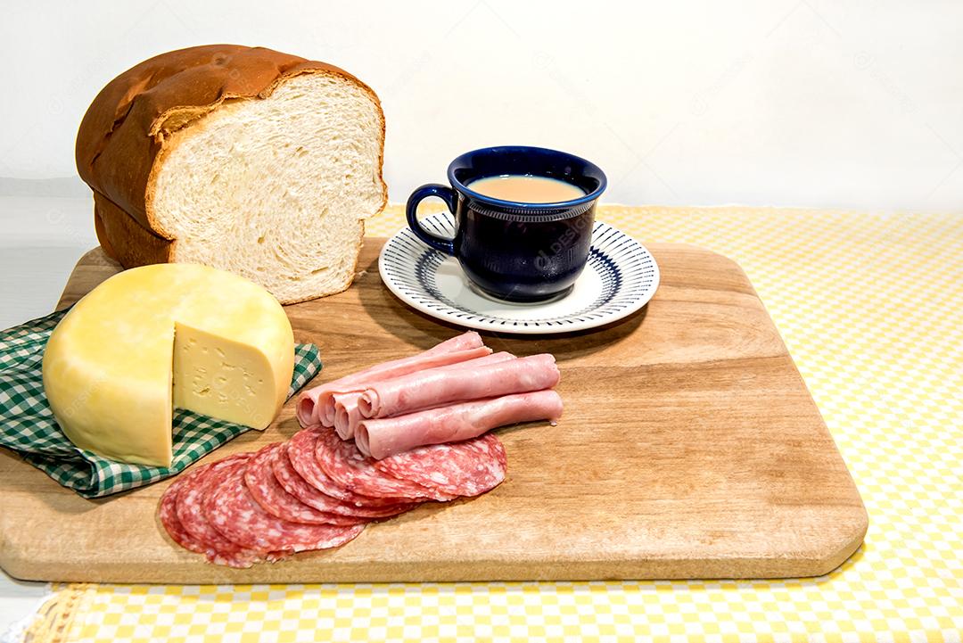 Café da manhã colonial servido com pão, queijo, presunto e salame