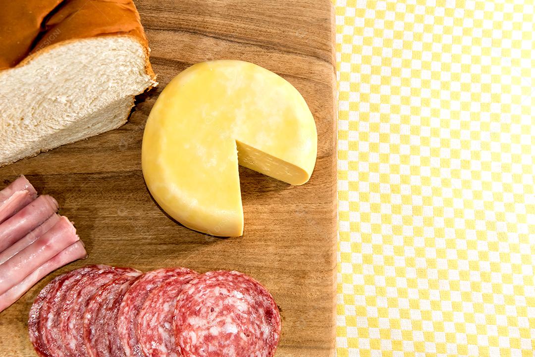 Café da manhã colonial servido com pão, queijo, presunto e salame