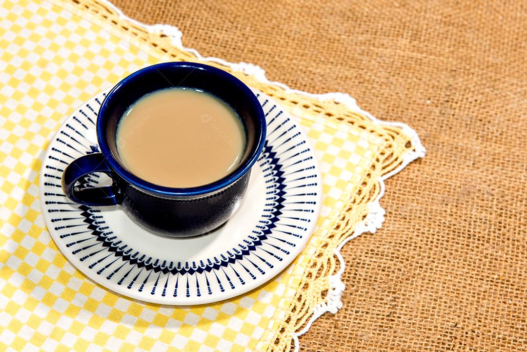 Xícara com café com leite na mesa colonial.
