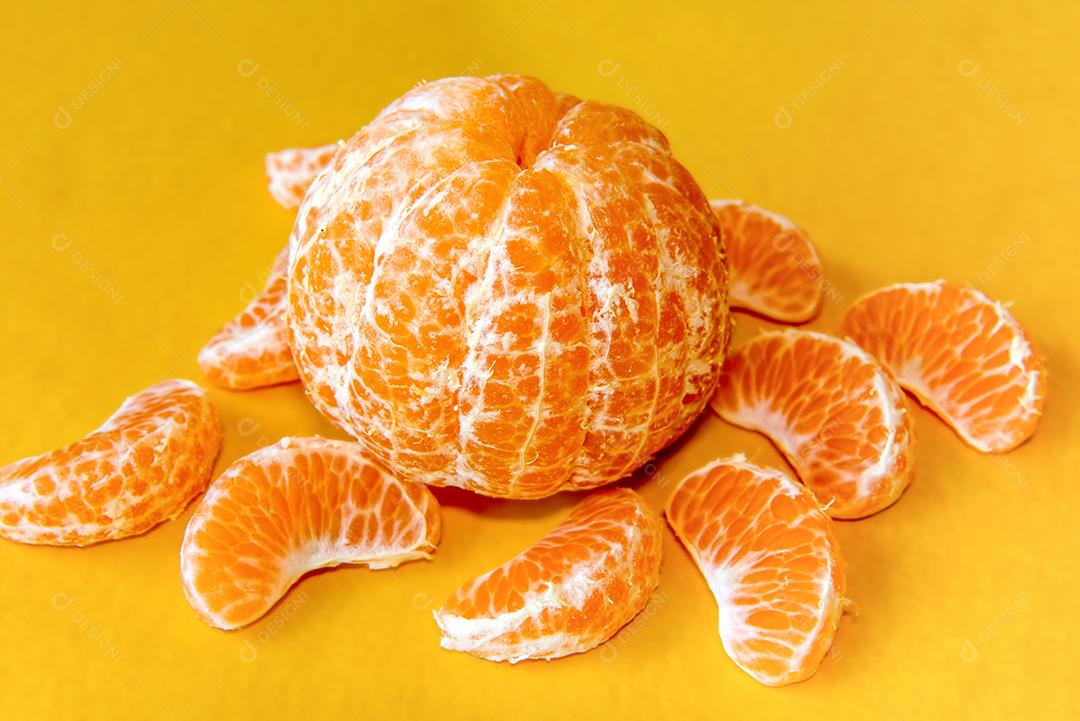 Bergamota mandarim em fundo amarelo.
