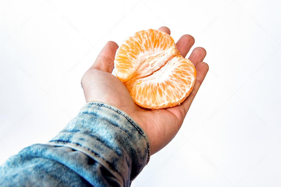 Mão segurando bergamota em fundo branco.