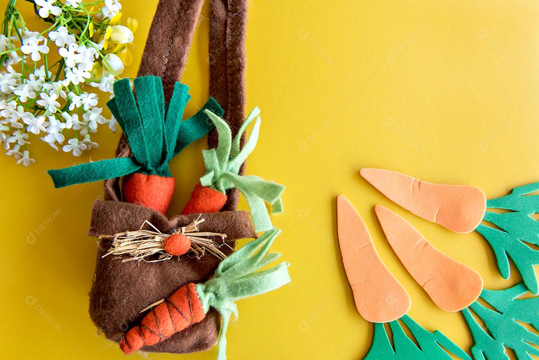 Fundo decorado de páscoa, cenouras de páscoa de pano nas costas amarelas