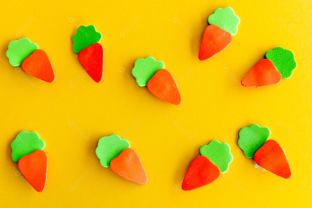 Fundo decorado de páscoa, cenouras de páscoa de pano nas costas amarelas