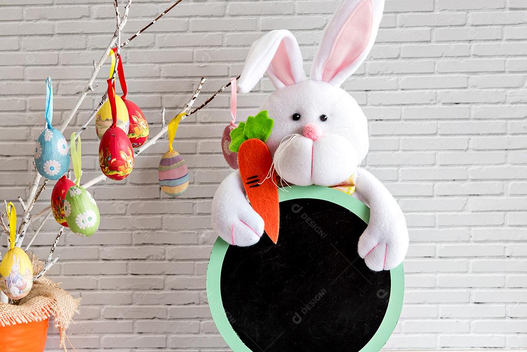 Decoração de páscoa, coelhinho da páscoa e cenouras em fundo amarelo