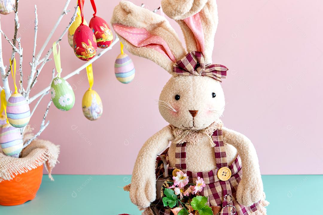 Coelhinho de pelúcia em fundo rosa e verde, coelhinho da páscoa.