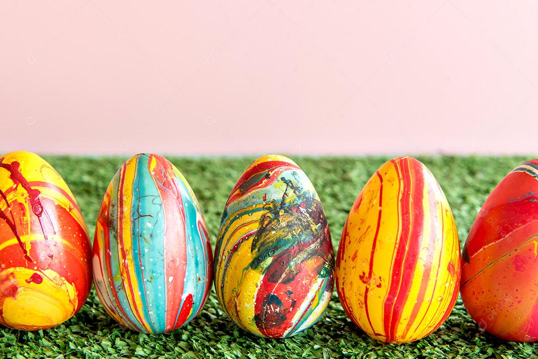 Decoração com ovos de páscoa coloridos no fundo da grama.