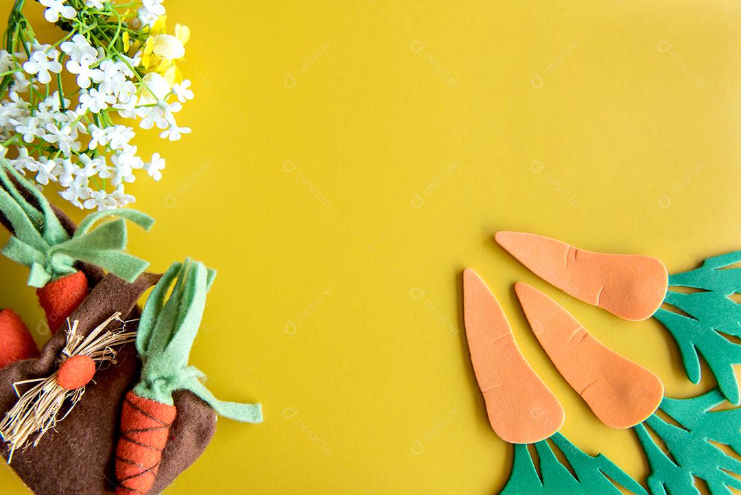 Decoração de páscoa, cenouras de páscoa em fundo amarelo.