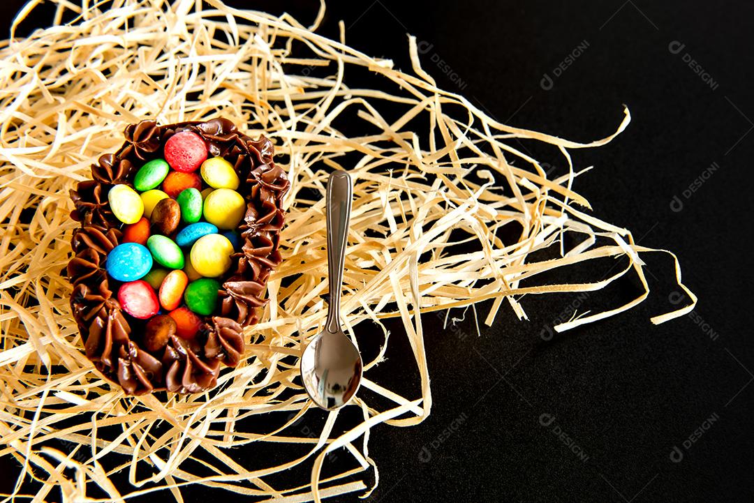Ovo de páscoa cheio de confete em fundo preto, páscoa