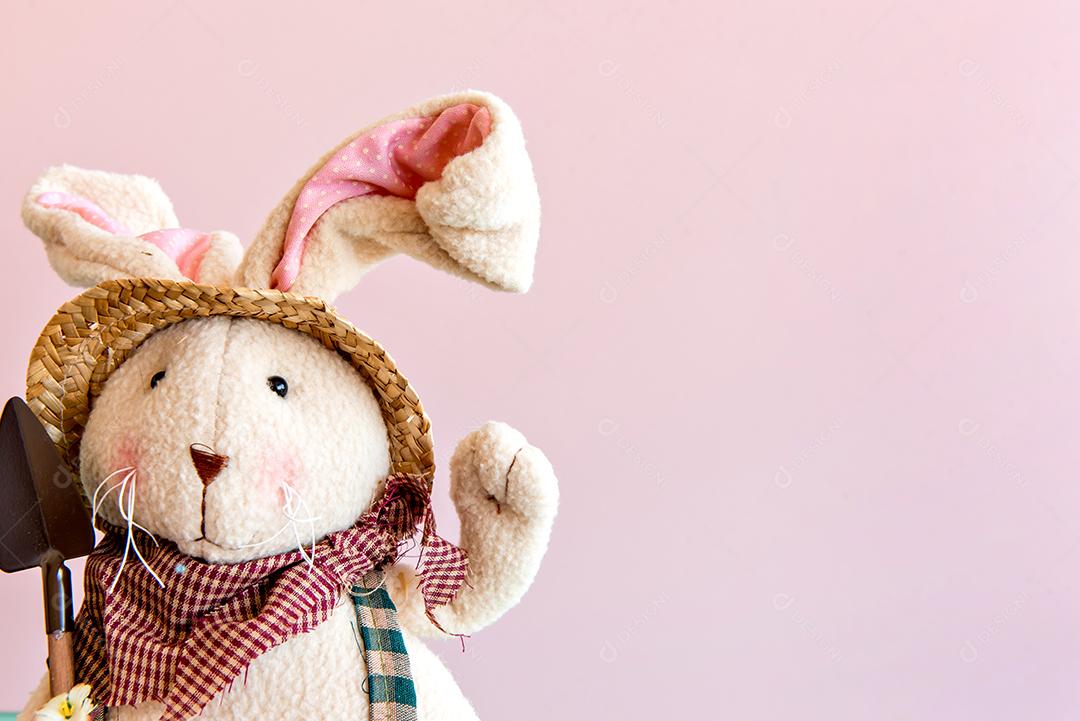 Coelhinho de pelúcia em fundo rosa.