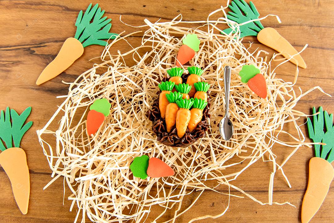 Ovo de páscoa cheio de chocolate no fundo da páscoa com cenouras