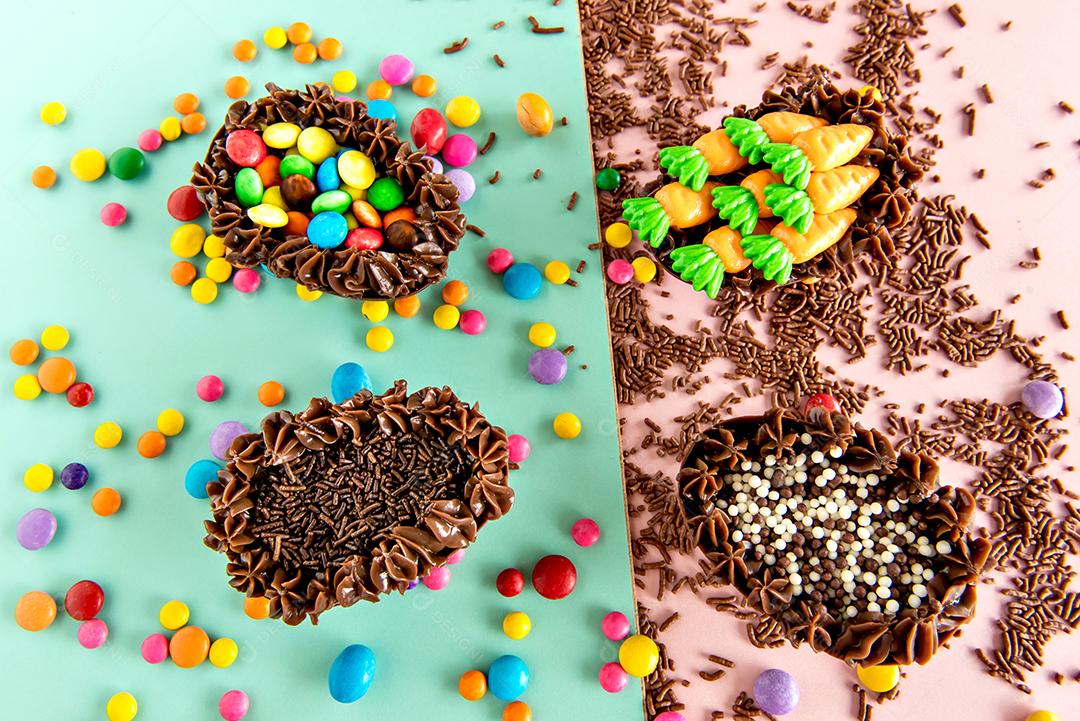 ovos de páscoa cheios de chocolate no fundo rosa com granulado