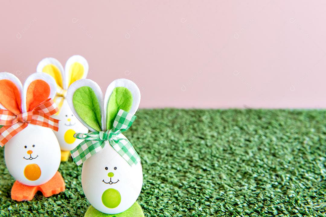 Conceito de páscoa, ovos de páscoa na grama no fundo rosa.