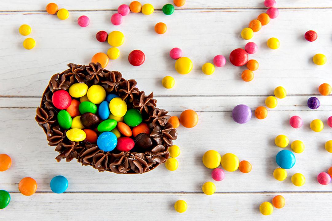 Ovo de páscoa cheio de confete em fundo branco, vista superior