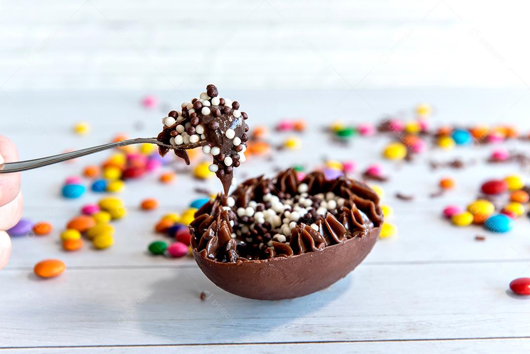 Conceito de páscoa, ovo de páscoa cheio de chocolate, colher cheia.