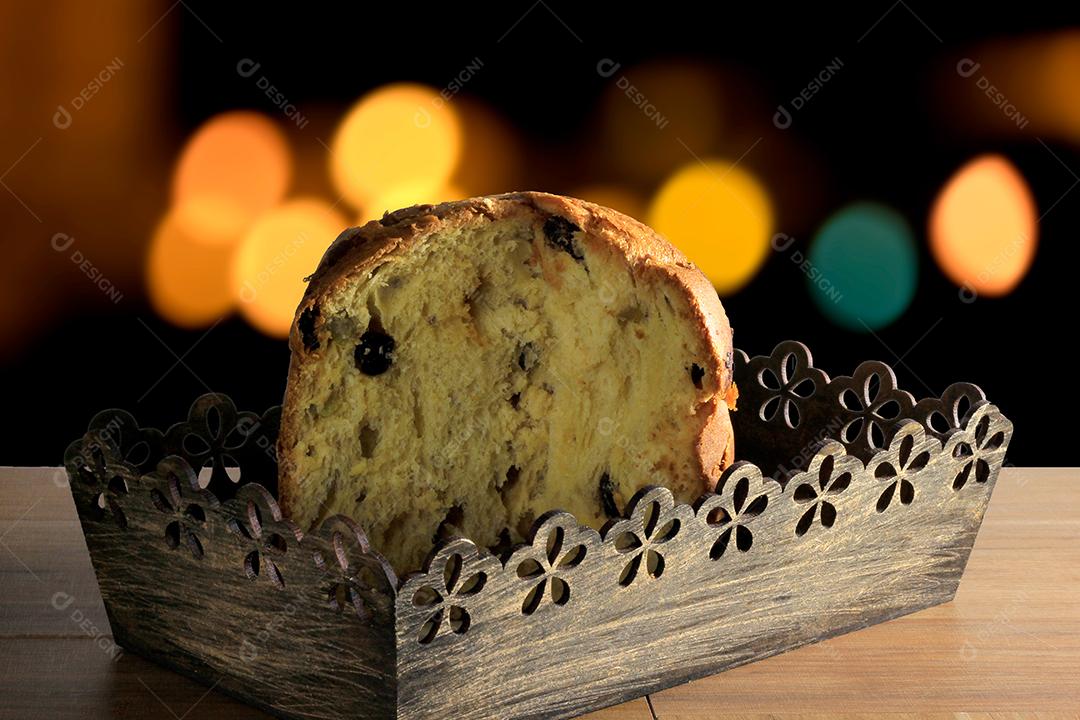 Panetone dentro da caixa na mesa de madeira com luzes de fundo